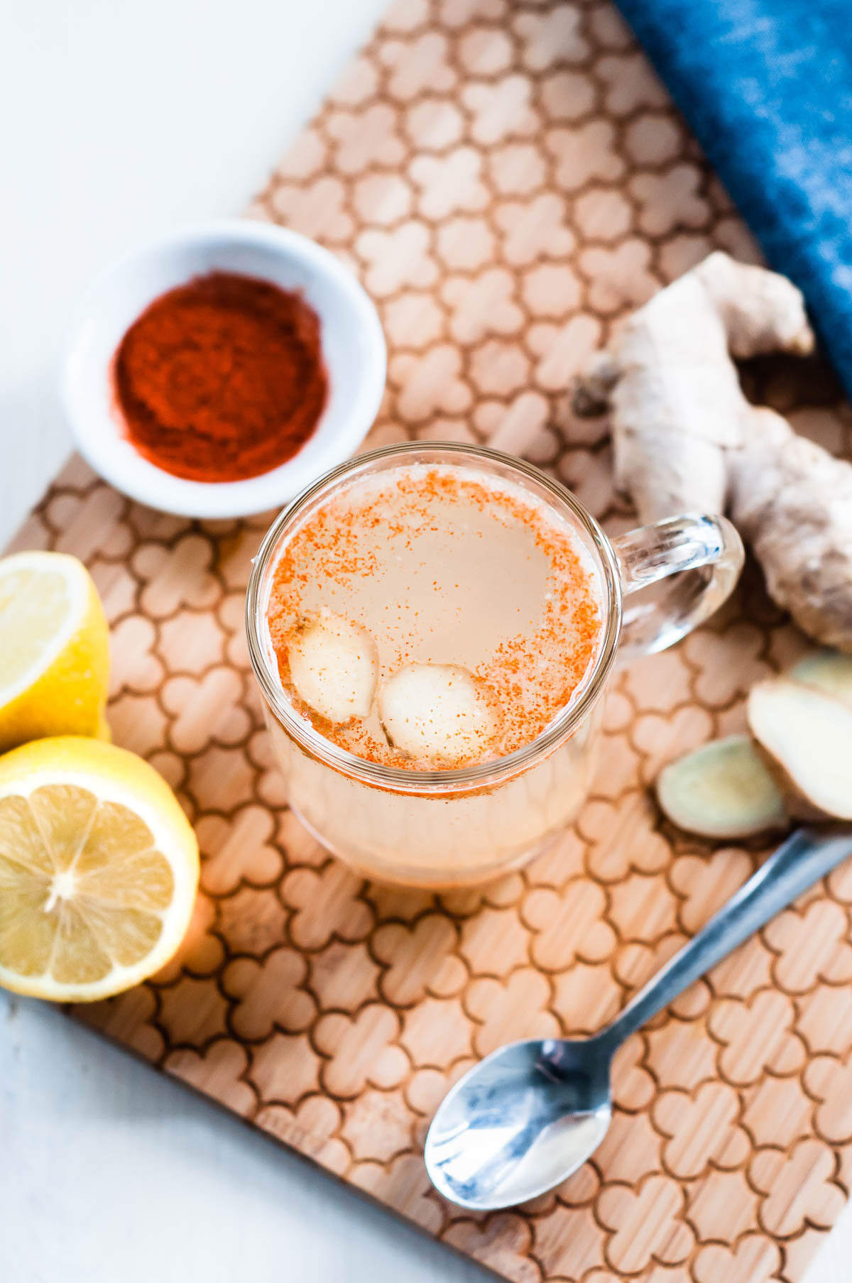 Glass mug of tea with lemon, ginger, and cayenne pepper makes a refreshing DIY detox tea.