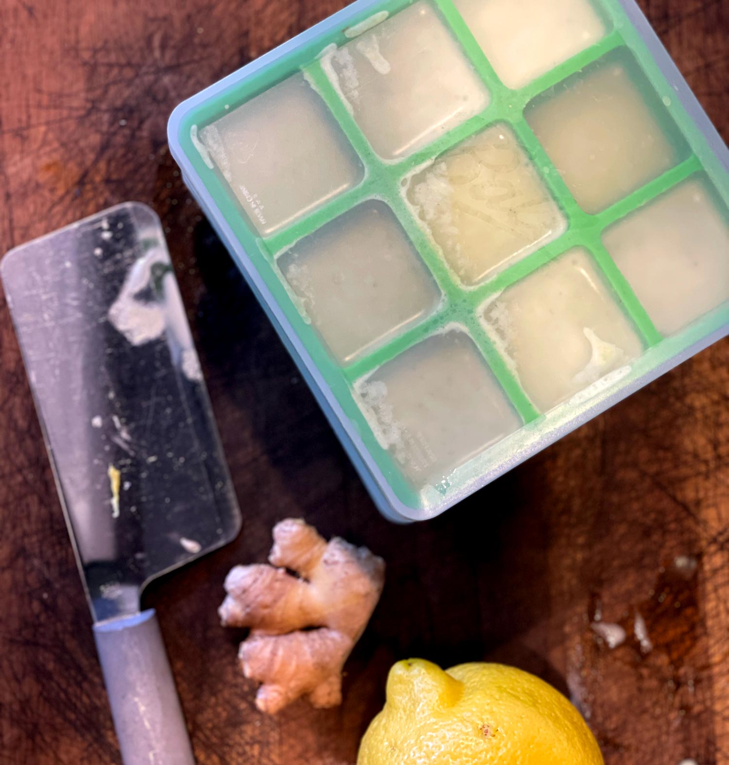 green ice cube tray with detox tea ingredients frozen inside