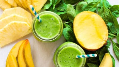 Fresh green smoothie with pineapple, mango, and spinach for a healthy recipe.