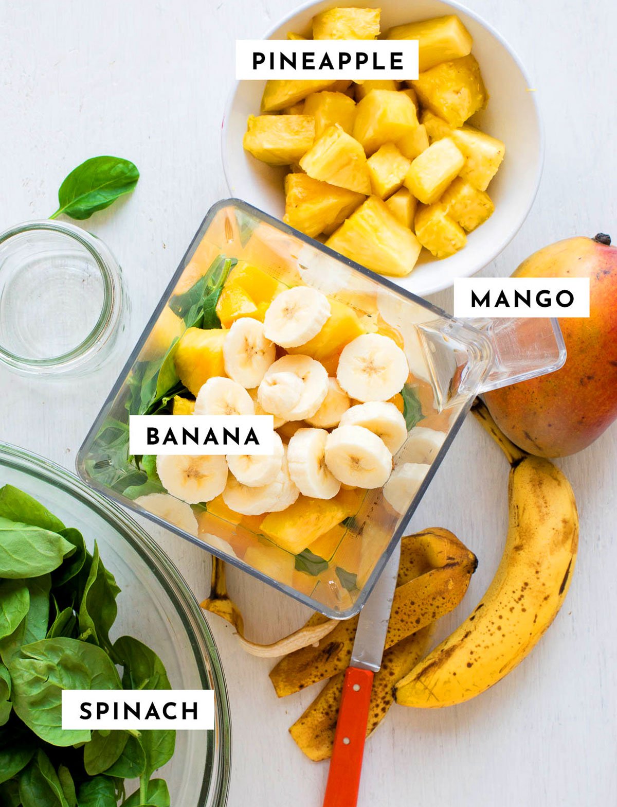 Labeled ingredients of pineapple, mango, banana and spinach for the best green smoothie recipe. 