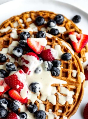 Best vegan waffles topped with cream and fresh berries.