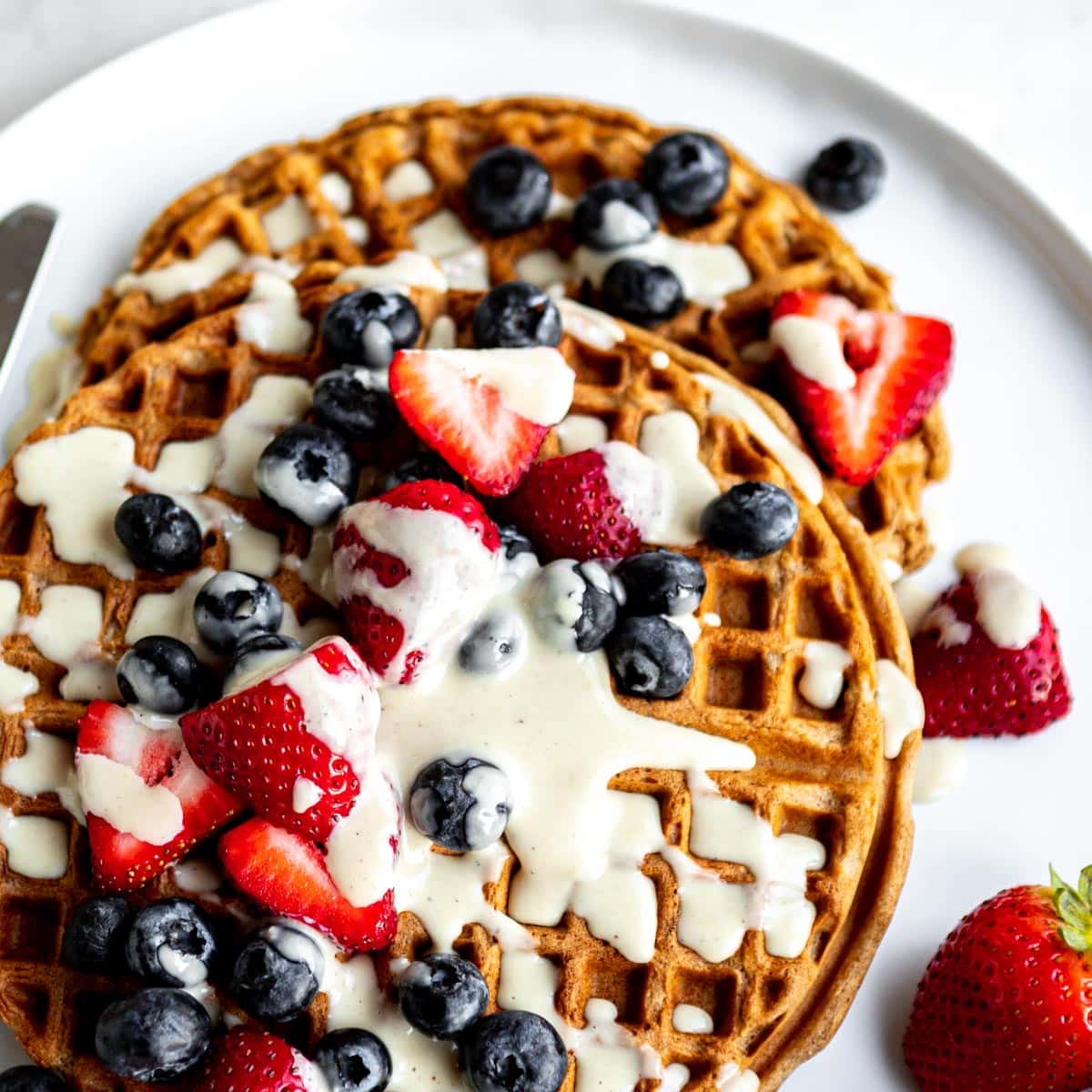 best vegan waffles topped with cream and fresh berries