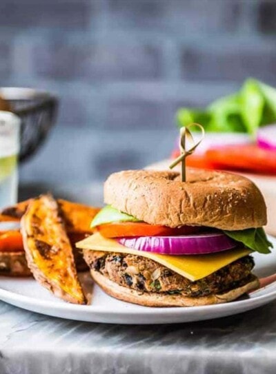 black bean burger with crispy sweet potato wedges on a plate.