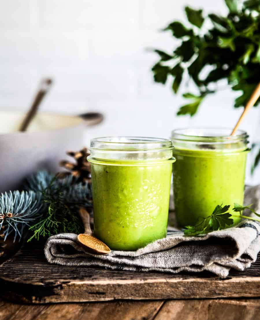 Bieler's broth in 2 glass jars on a cloth napkin surrounded by greenery.