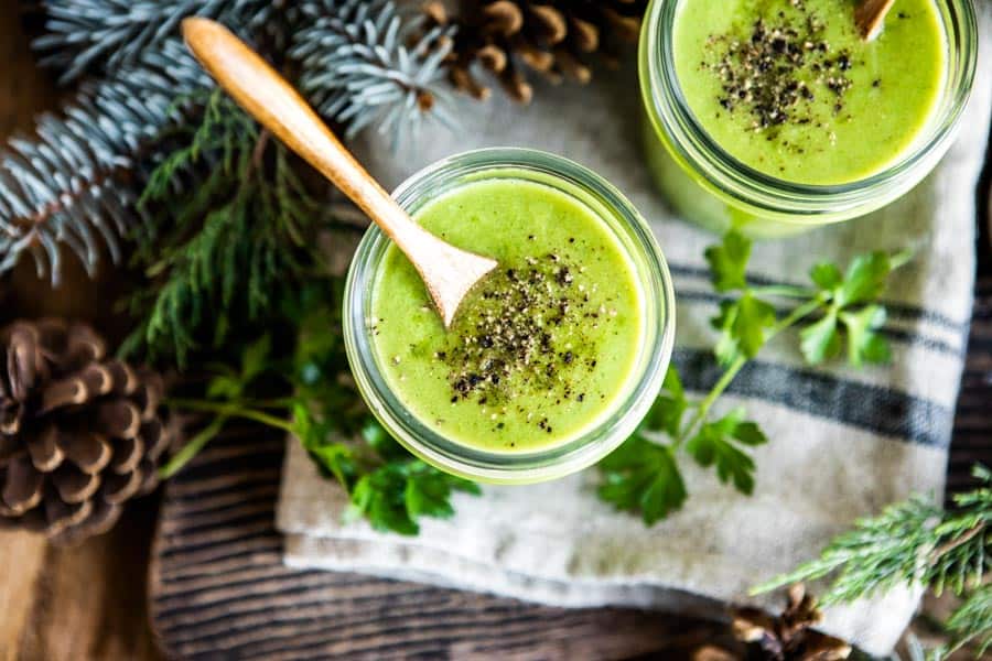 blended vegetable soup recipe in 2 glasses with wooden spoons.