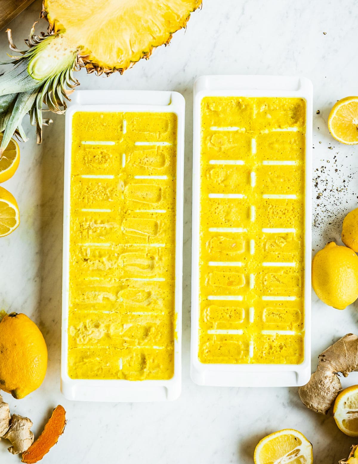 2 white ice cube trays full of turmeric blender bombs ready to be stored.