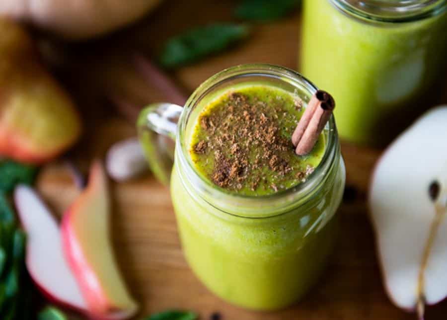 warm butternut squash smoothie in a glass mug with a cinnamon stick on top.