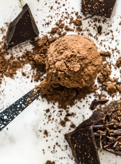 spoonful of cacao powder and broken pieces of chocolate in this cacao powder recipes round up.