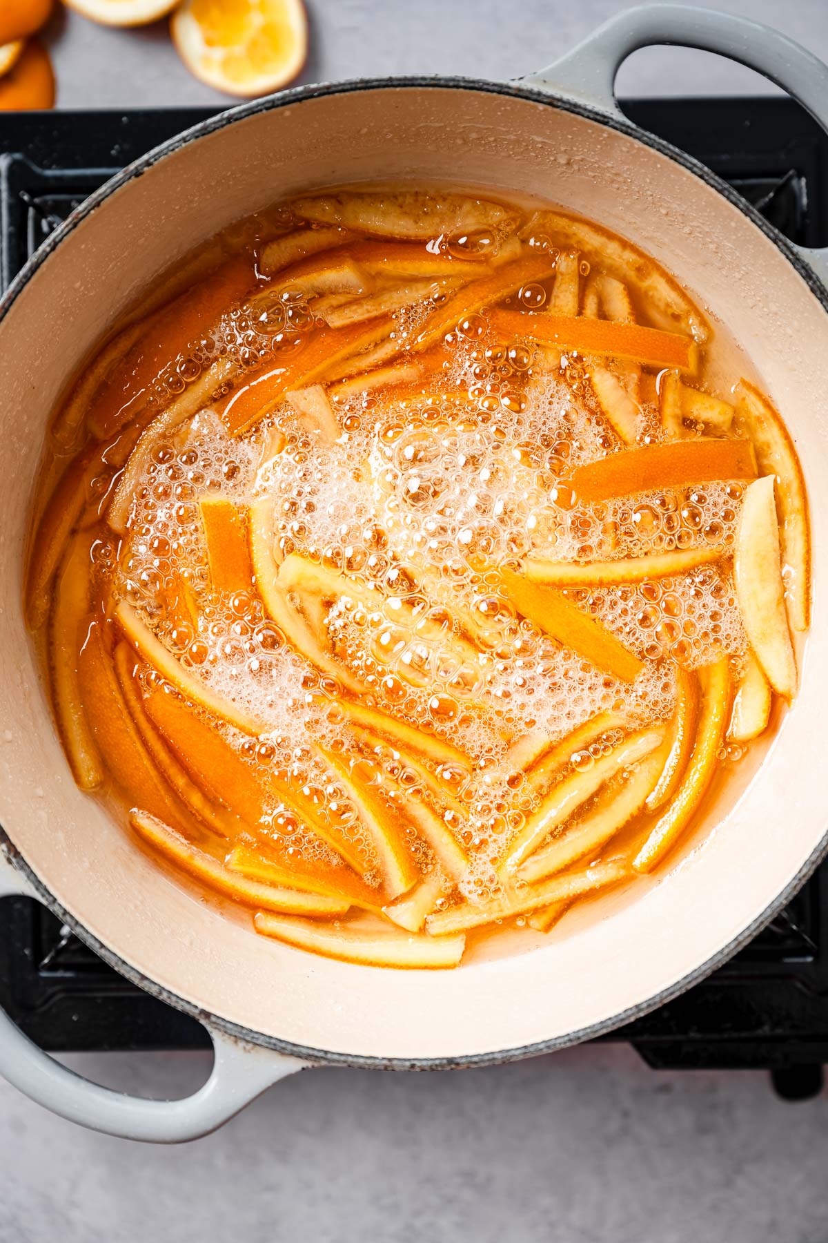Orange peels boiling in a pot of sugary syrup
