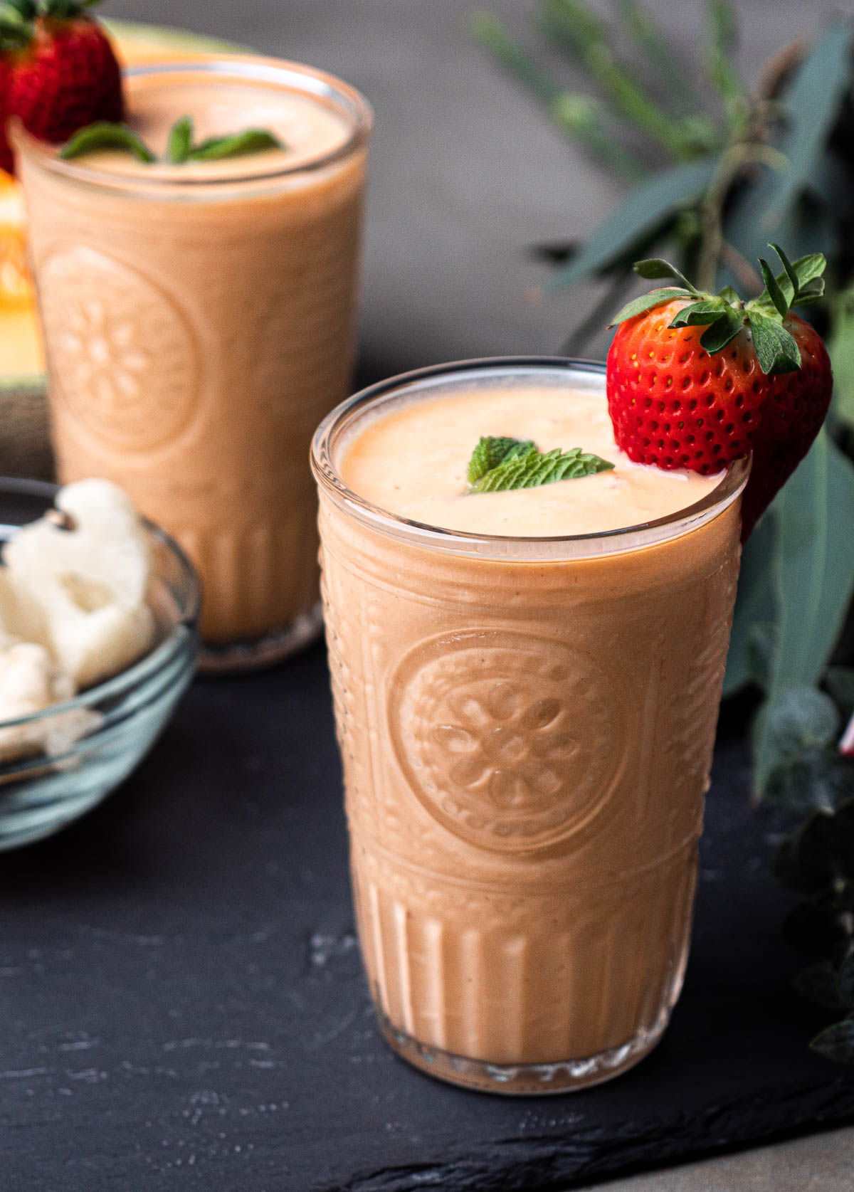 cantaloupe smoothie with fresh strawberry and a mint leaf