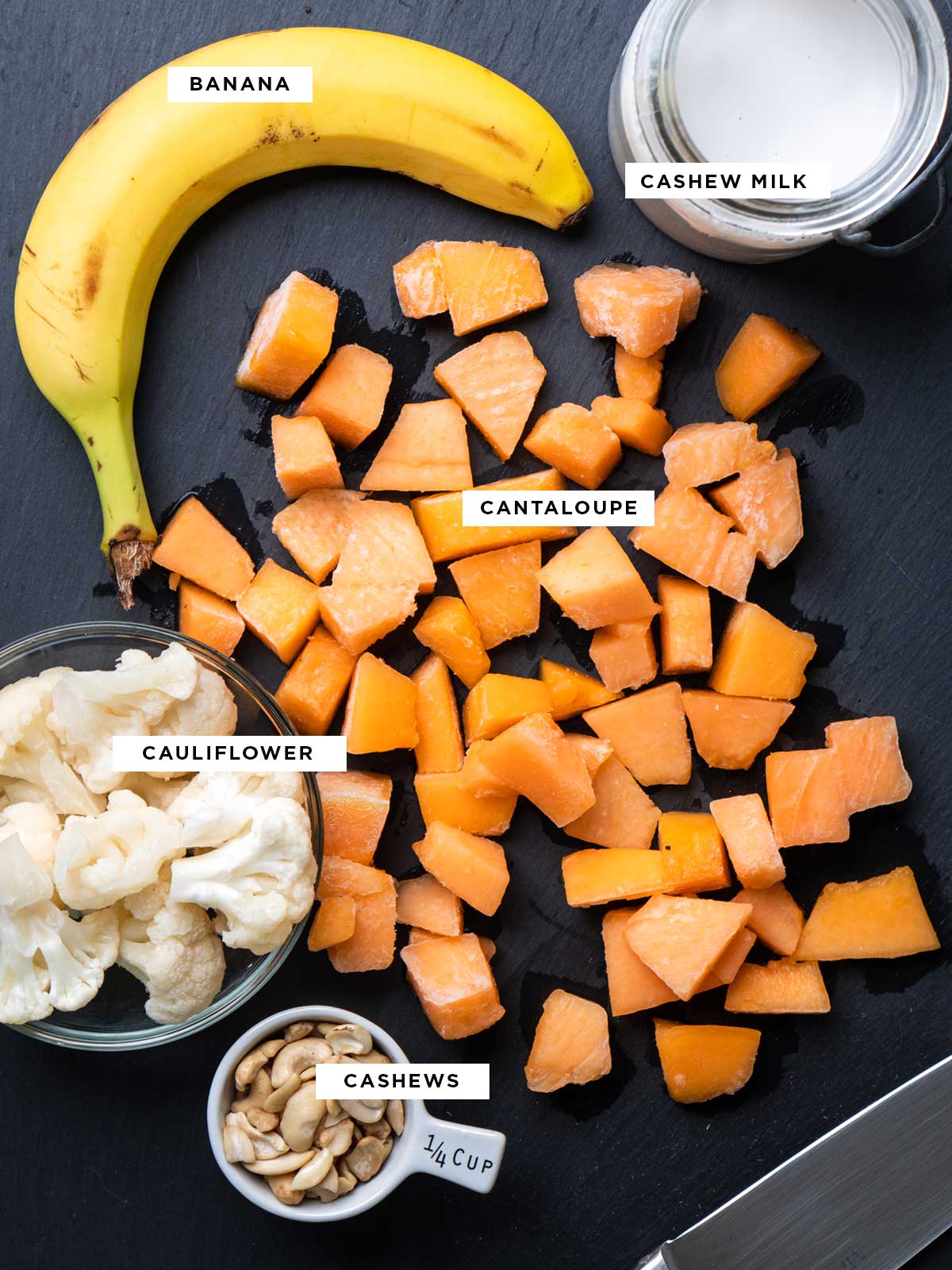 ingredients for a cantaloupe banana smoothie including banana, frozen cantaloupe, cauliflower, cashews and cashew milk.