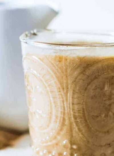 Healthy caramel protein shake in an etched glass next to pitted dates