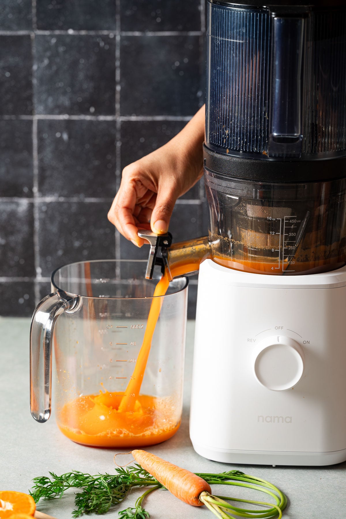 A person opening the juicer spout to release fresh juice