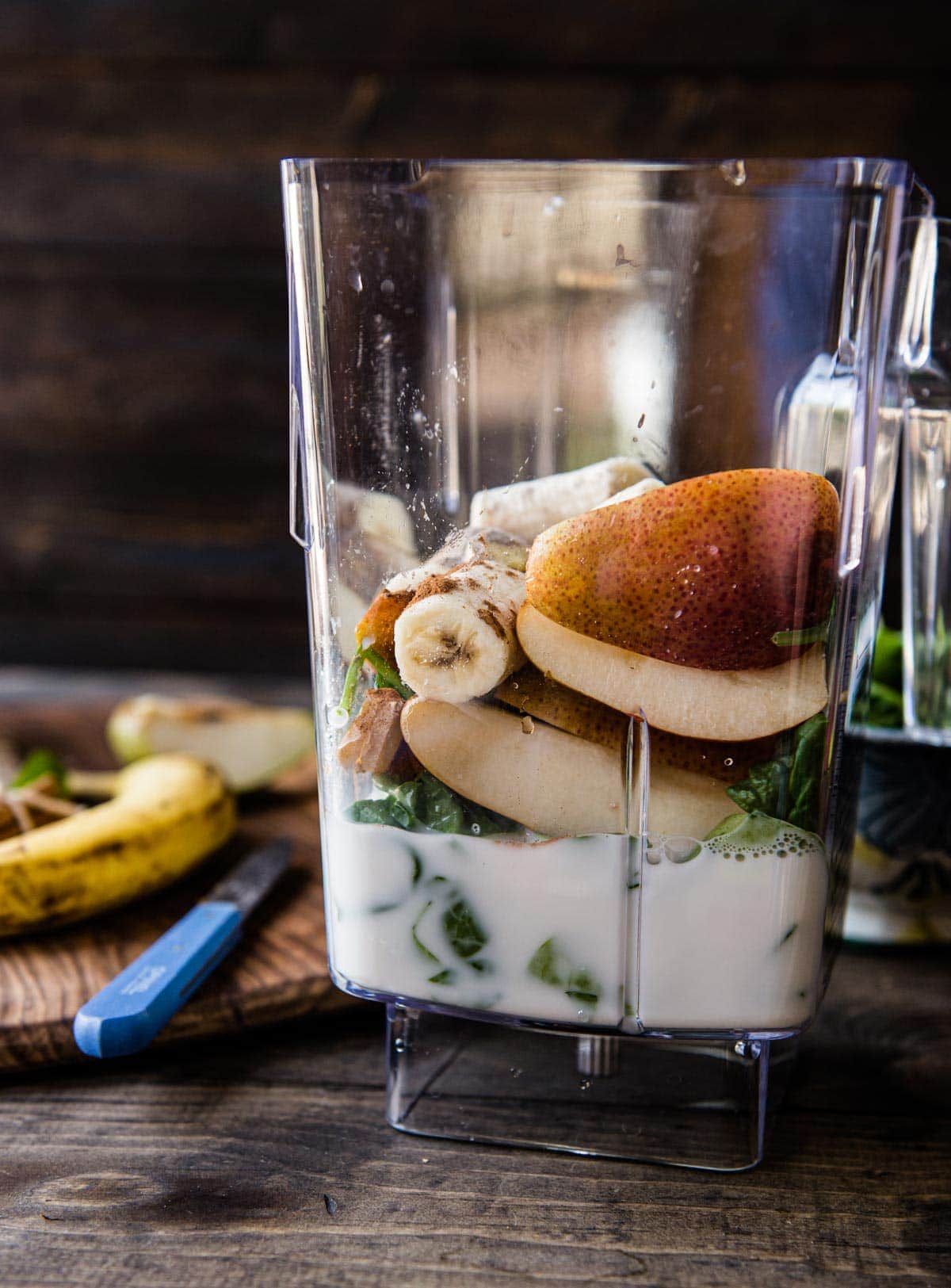 Blender filled with ingredients for a warm chai smoothie. 