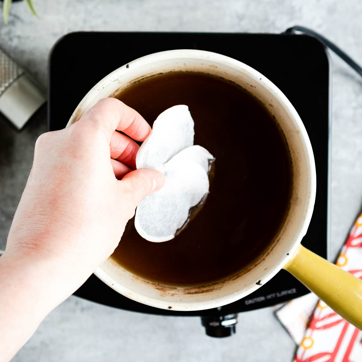 Adding tea bags to a spiced water mix