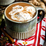 chai tea latte in a mug topped with homemade coconut whipped cream.