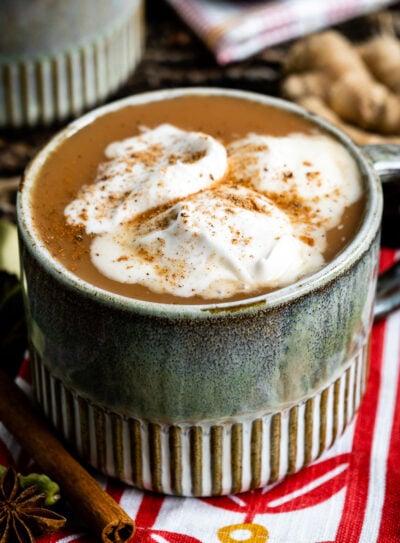 A cup of chai latte with whipped coconut cream on top