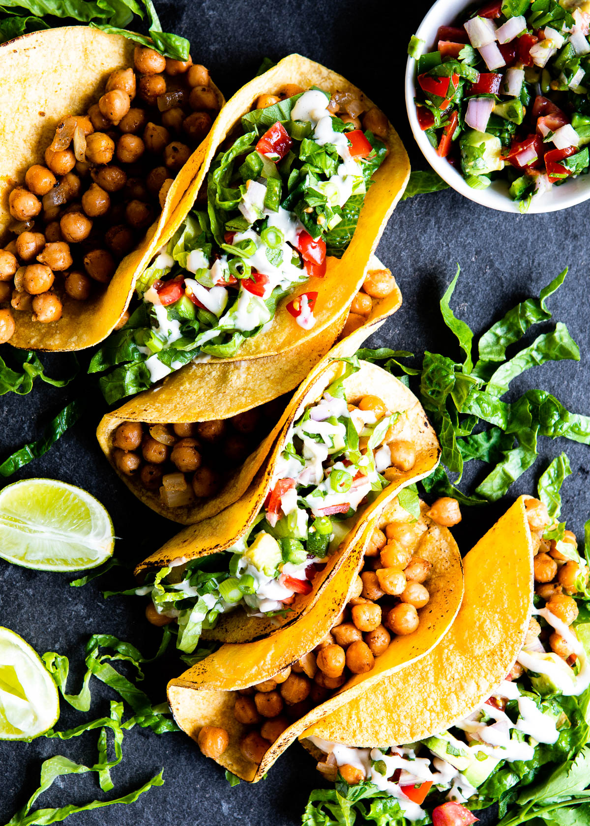 a line of tacos, every other one topped with fresh toppings