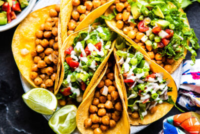 Chickpea tacos on plate with fresh lime wedges.