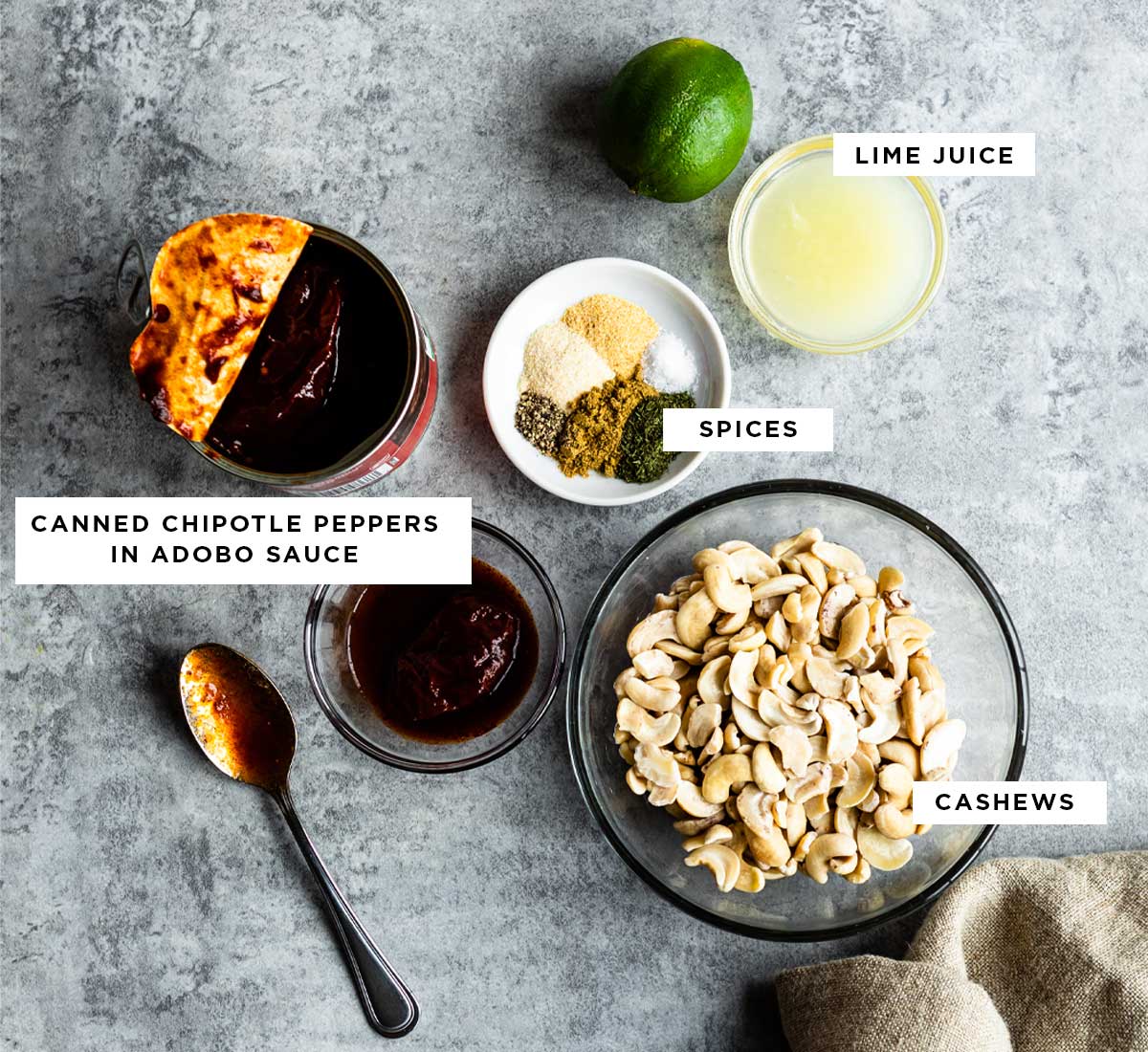 ingredients for chipotle ranch including lime juice, canned chipotle peppers in adobo sauce, spices and cashews.