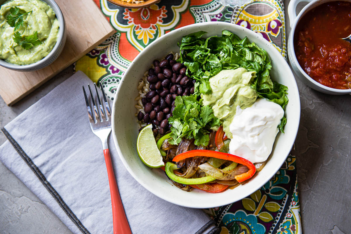 A healthy chipotle veggie bowl with roasted bell peppers.