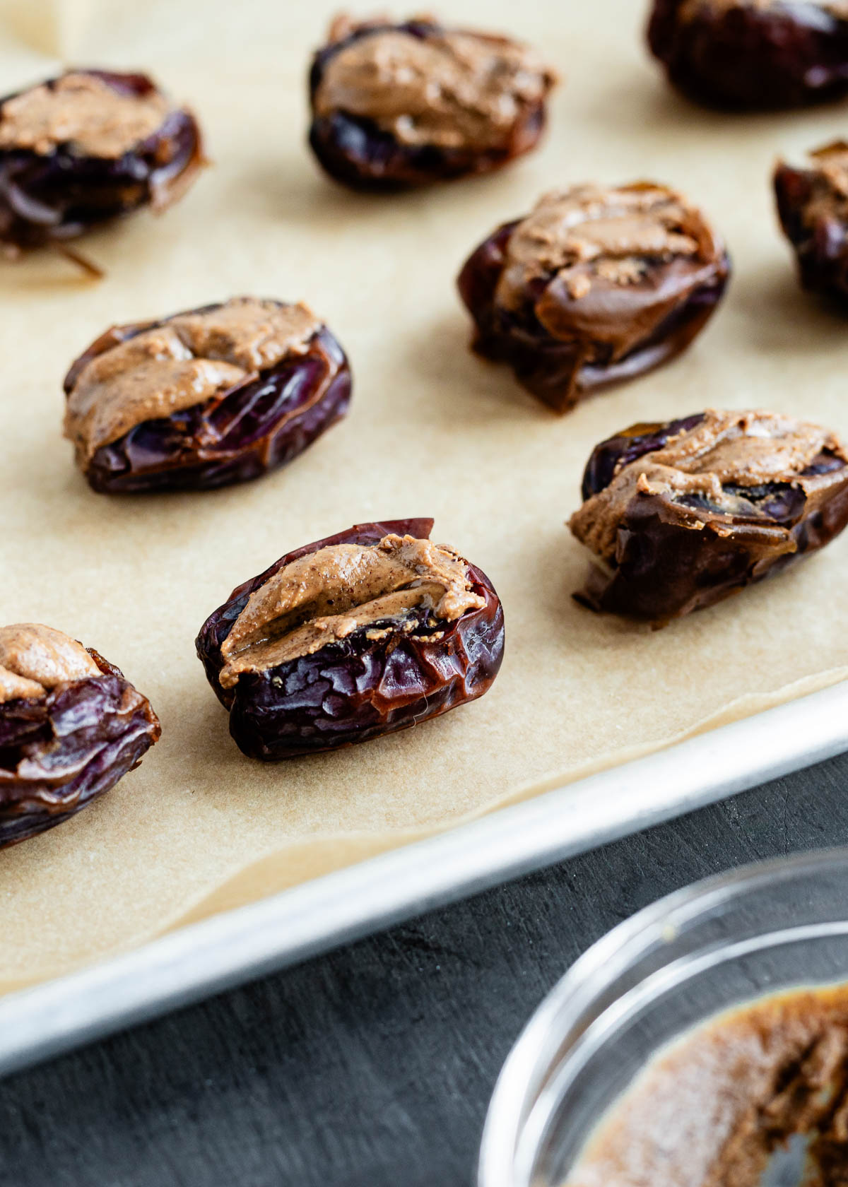 Pitted Medjool dates filled with almond butter for a chocolate covered dates recipe.