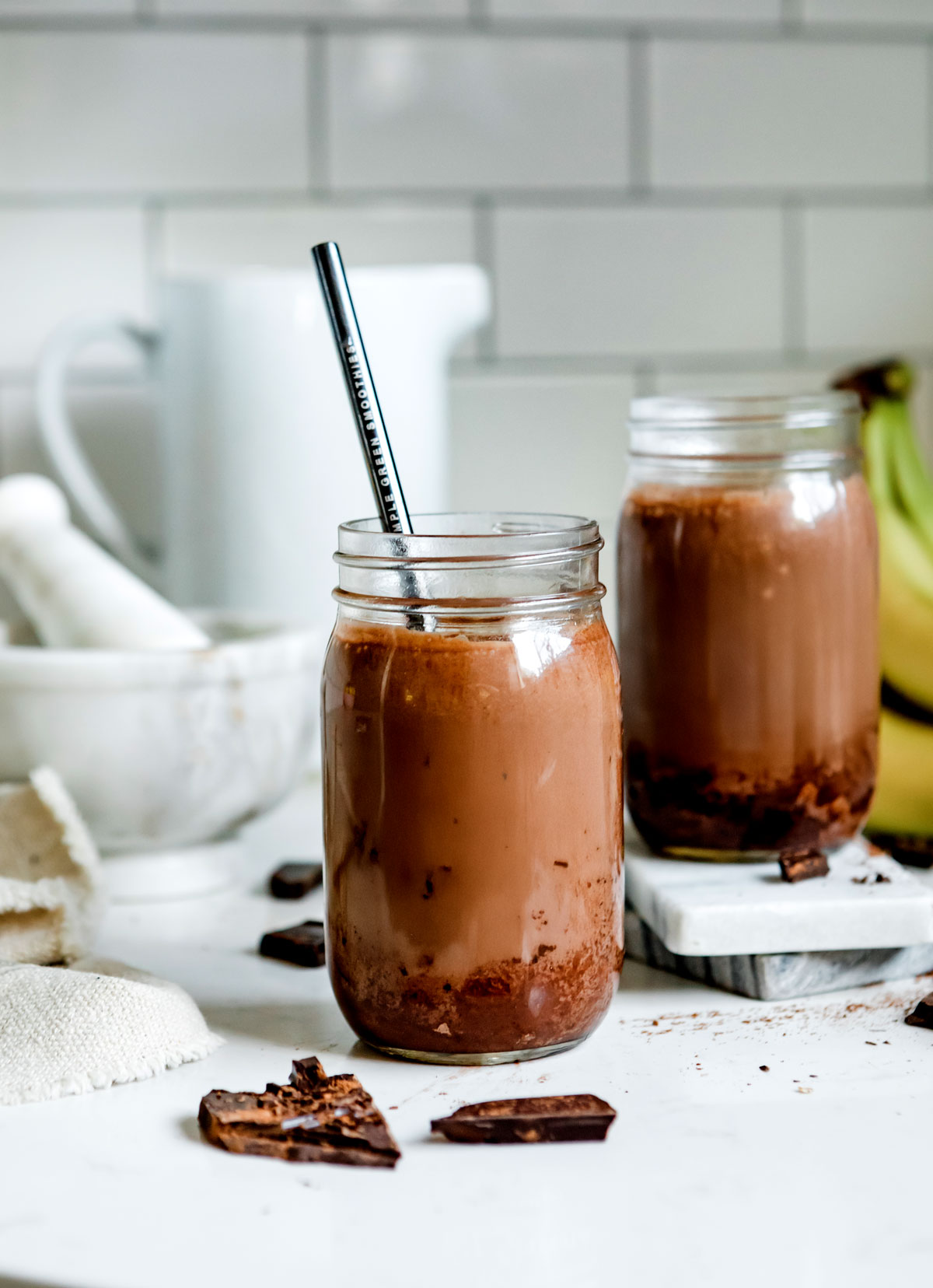 Two jars of chocolate peanut butter smoothie ready to drink.