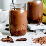 Chocolate peanut butter smoothie in two jars with straws.