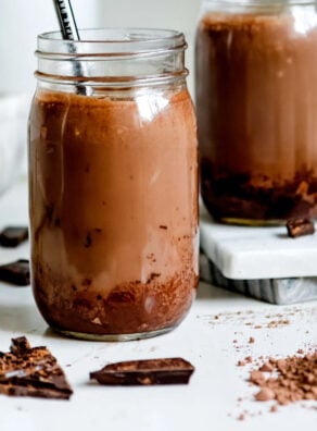 Chocolate peanut butter smoothie in two jars with straws.