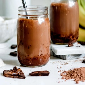 Chocolate peanut butter smoothie in two jars with straws.