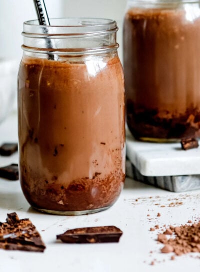 Chocolate peanut butter smoothie in two jars with straws.