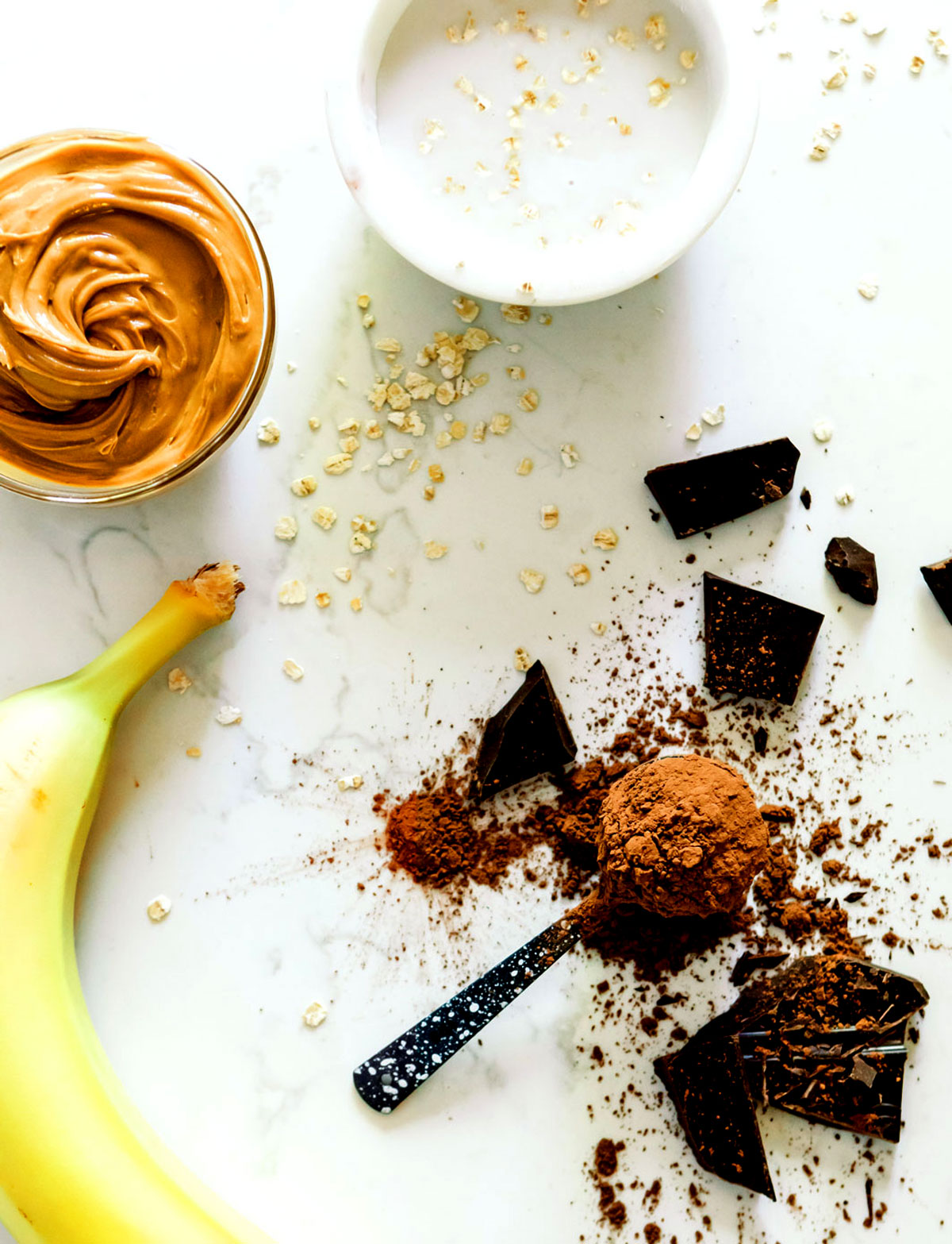 Ingredients for a chocolate peanut butter smoothie laid out on a counter.