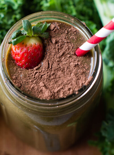 Chocolate strawberry smoothie with a straw and a strawberry.