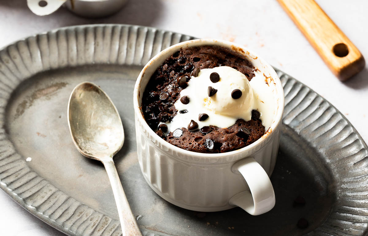 A vegan chocolate mug cake with a spoon. 