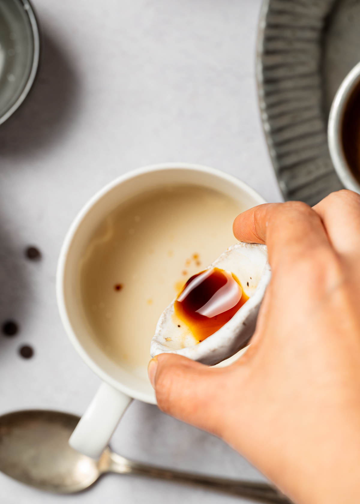 Wet ingredients being poured into a vegan chocolate mug cake. 