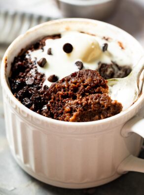 A vegan chocolate mug cake topped with dairy free ice cream.