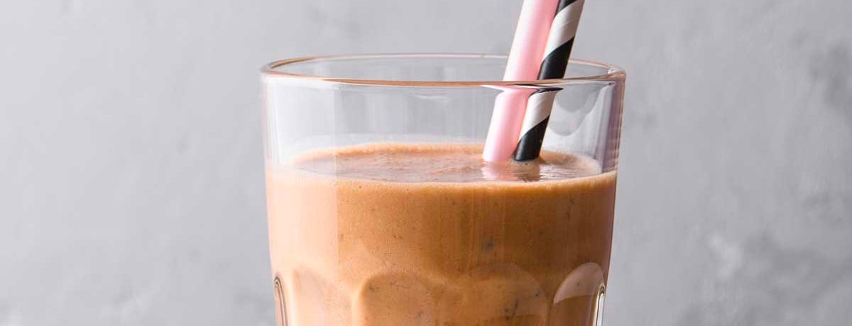 chocolate smoothie for weight loss in an old fashioned glass with a pink straw and a black straw