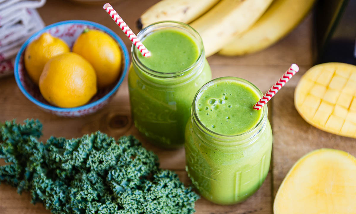 2 glass jars with striped straws of citrus smoothie.