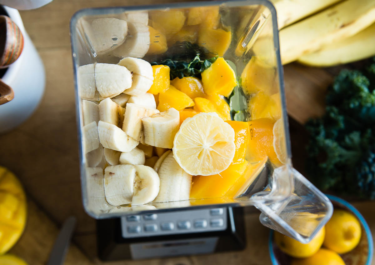 overhead photo of blender full of fresh ingredients for a delicious citrus smoothie