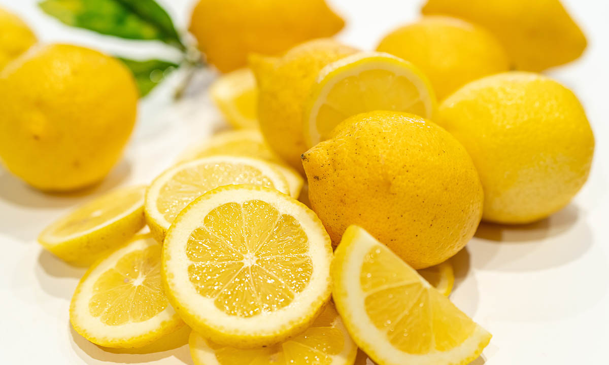 sliced and whole lemons in a group.