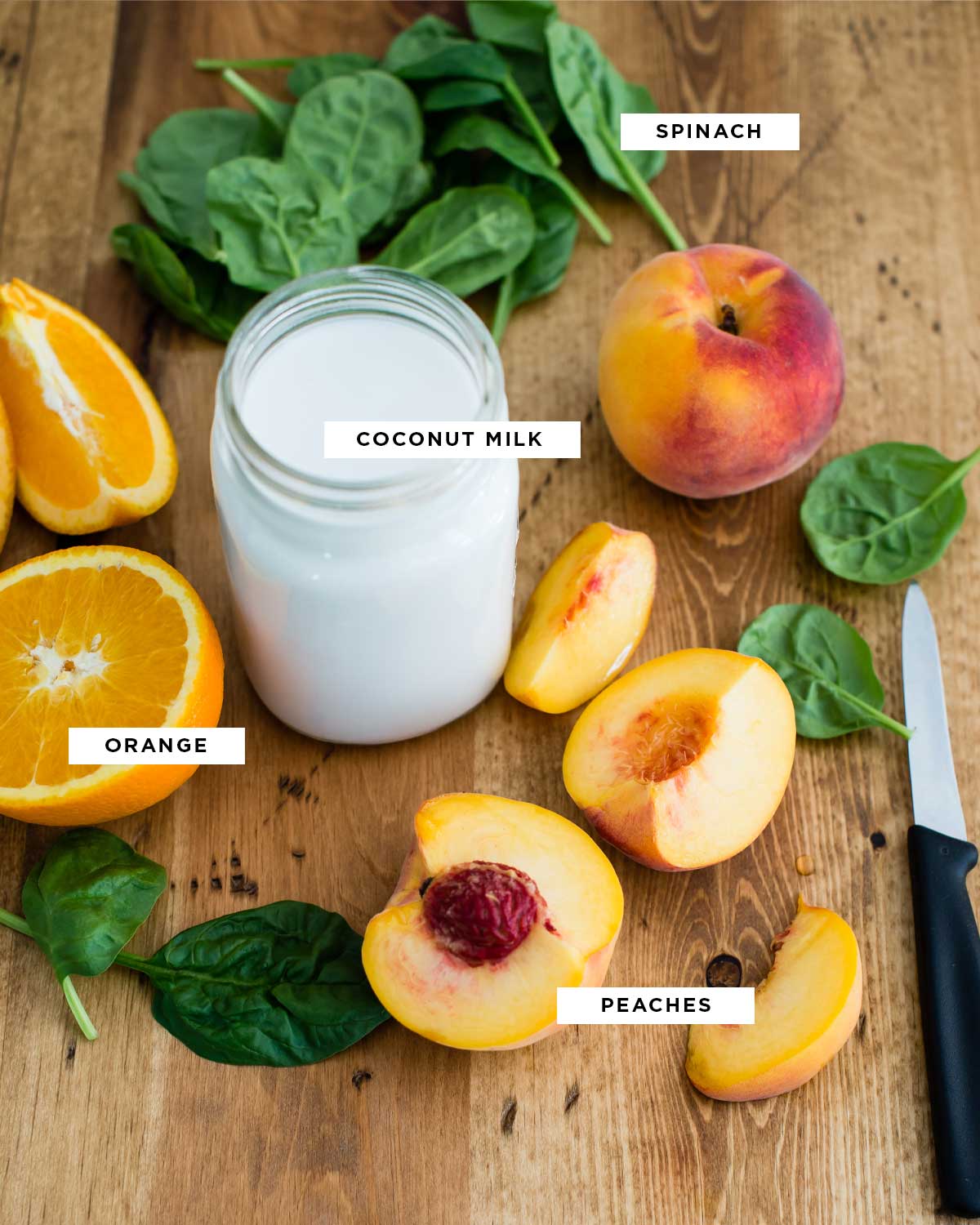 ingredients for this coconut milk smoothie recipe including spinach, coconut milk, fresh peaches and fresh oranges.