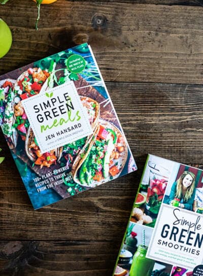 Simple Green Meals cookbook on a rustic wooden table with smoothies and plants.