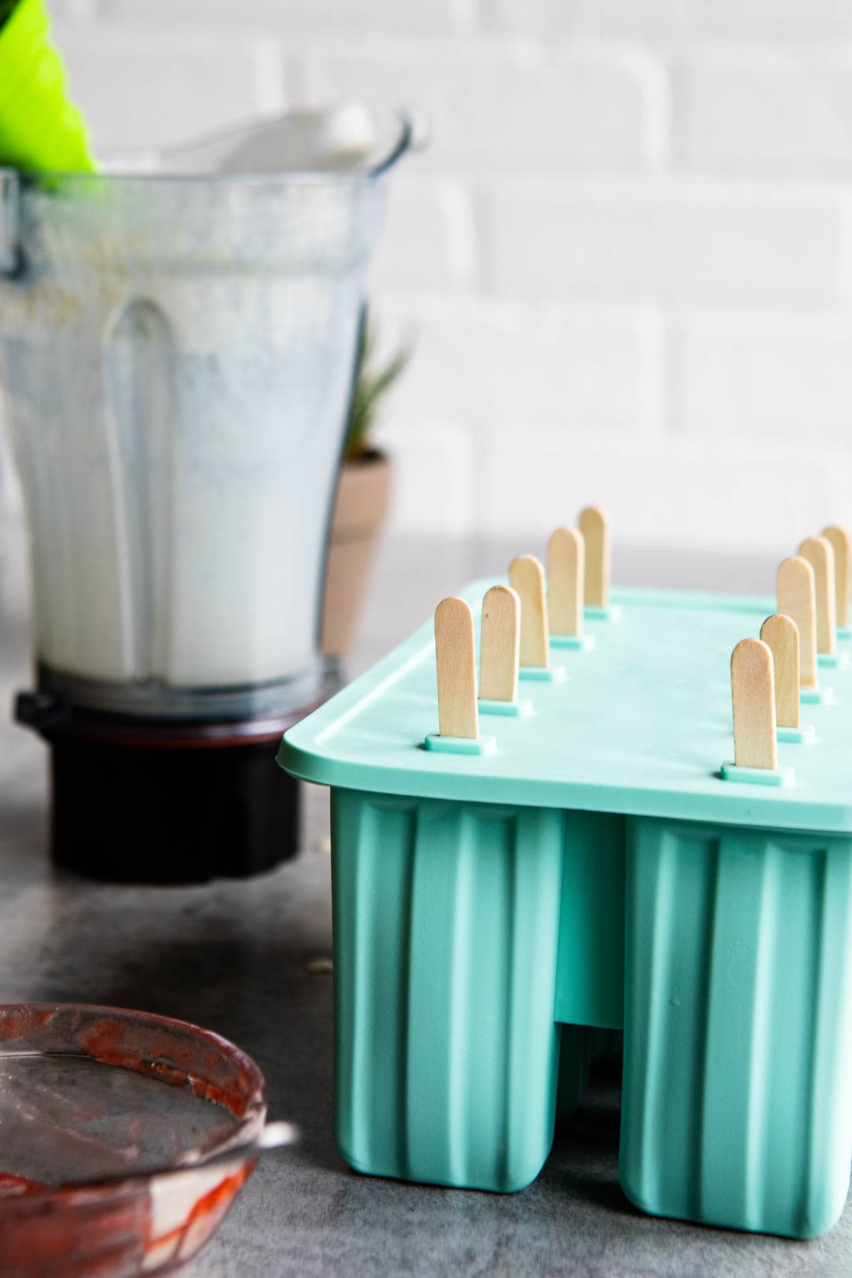 blue popsicle molds with wooden sticks sticking out the top.