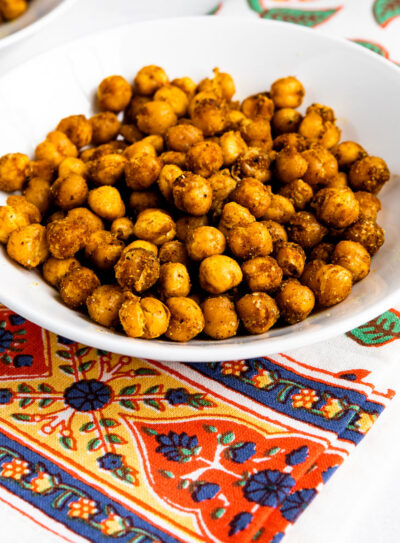 Curry roasted chickpeas in a serving bowl on a white table.