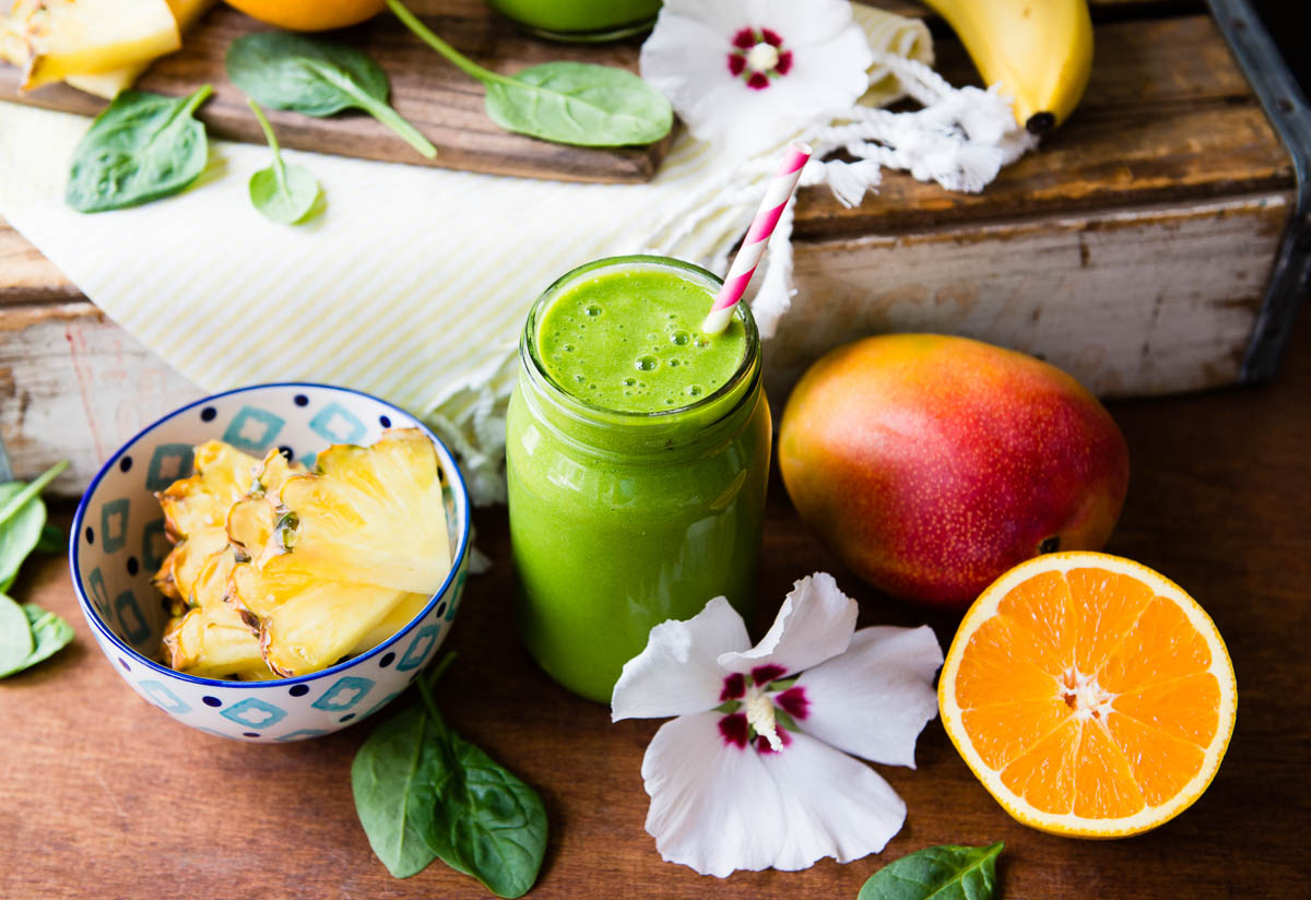 Detox island green smoothie surrounded by tropical ingredients. 