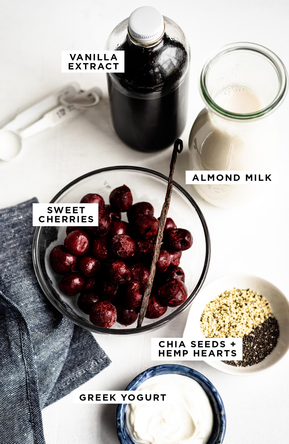 labeled ingredients for a diabetes smoothie including vanilla extract, almond milk, sweet cherries, chia seeds & hemp hearts and greek yogurt.