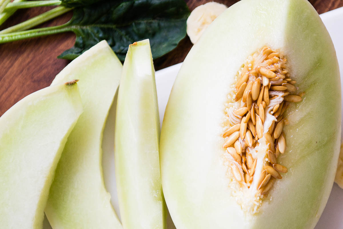 several slices of honeydew melon, one with seeds.