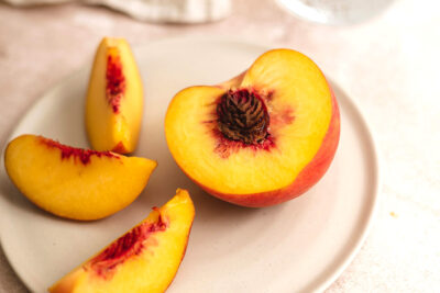 dirty dozen peaches cut in half on counter