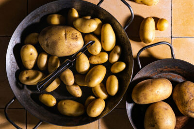 Dirty potatoes in bowl getting washed and peeled