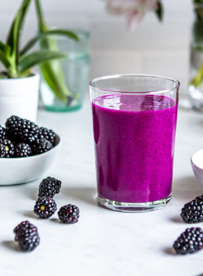 Elderberry smoothie recipe getting poured into a clear glass.